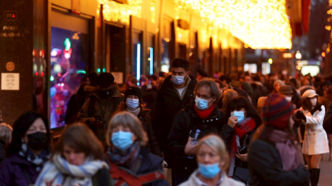 Ciudadanos con mascarillas pasean por una calle de París.