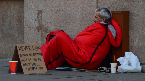 Una persona sin hogar pidiendo en la calle.