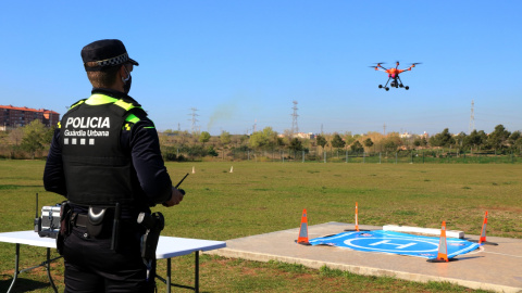 Un agent de la Guàrdia Urbana de Tarragona fent aterrar el dron del cos policial durant una demostració a Campclar. 24 de març del 2021.