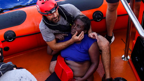 Un miembro de Open Arms rescata a un mujer, en estado de 'shock', en el Mediterráneo. REUTERS