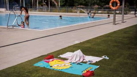 Toallas infantiles en el césped de una piscina el día de apertura de las piscinas públicas, en la piscina del Centro Deportivo Municipal (CDM) José María Cagigal