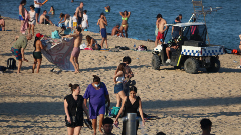 Un vehicle de la Guàrdia Urbana demana als banyistes que abandonin la platja de la Nova Icària, abans de tancar-la aquesta Nit de Sant Joan. 23 de juny de 2020.