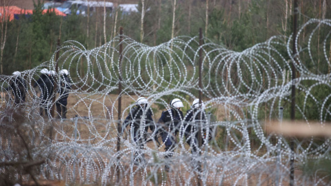 18/11/2021 Agentes de la ley polacos caminan en la región fronteriza entre Bielorrusia y Polonia de Grodno.