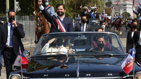 El presidente de Chile, Gabriel Boric, saluda a sus simpatizantes a bordo del vehículo presidencial Ford Galaxie donado por la reina Isabel II de Inglaterra, mientras reciben honores de las Fuerzas de Armadas tras ser investido este 11 de marzo de 2022.