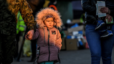 11/03/2022 Un militar ayuda a una niña después de que atravesara con su familia la frontera ucraniana con Polonia por Medyka