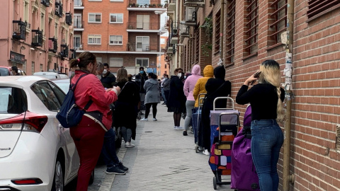 Fila de personas, en su mayoría mujeres, que esperan su turno para entrar en Cáritas, en Madrid. - EFE