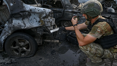 Un experto analiza un coche destruido por las tropas rusas en Vilniansk, a 29 de junio de 2024.