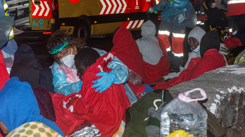 Ocupantes de la embarcación encallada en Órzola, en Lanzarote, con el equipo de emergencia.