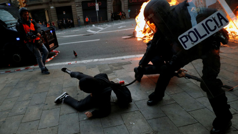 Un agente de la Policía Nacional golpe a un manifestante. / Reuters