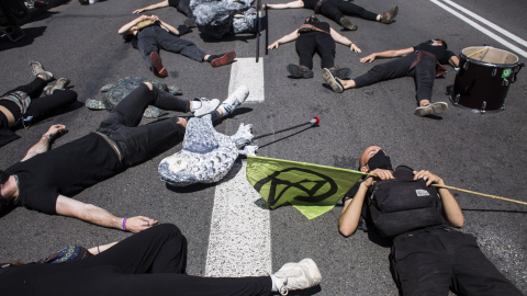 04/06/2021. Varias personas yacen en el suelo como parte de una acción posterior a la entrega del Manifiesto por la criminalización del Ecocidio, este viernes en Madrid. - EUROPA PRESS