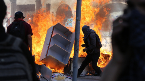 22-10-19 / Varios encapuchados montan barricadas frente a la policía tras manifestarse este martes en el centro de Santiago (Chile).  EFE/Elvis González