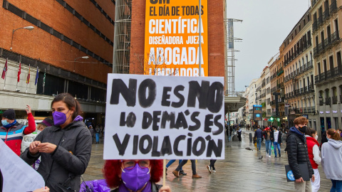 Una mujer sostiene una pancarta donde se lee "No es no, lo demás es violación", durante un acto simbólico del Movimiento Feminista de Madrid en la Plaza de Callao, en Madrid (España), a 8 de marzo de 2021.