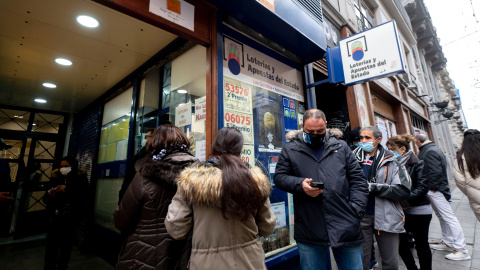 Varias personas hacen cola en una administración de Loterías del centro de Madrid cuando quedan menos de tres semanas para el Sorteo Extraordinario de la Lotería de Navidad, a 7 de diciembre de 2021, en Madrid (España).