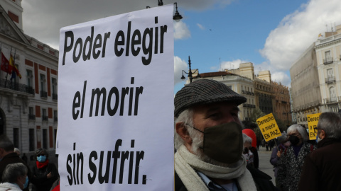 Un hombre con un cartel en el que se lee: `Poder elegir el morir sin sufrir´ durante una concentración de Derecho a Morir Dignamente en la Puerta del Sol, en Madrid (España), a 18 de marzo de 2021.