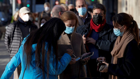 Varias personas hacen cola para vacunarse ante la sede de Casa Seat en Barcelona, uno de los puntos de vacunación fijos donde el Departamento de Salud ha retomado este lunes la estrategia de vacunación con dos vehículos adaptados para uso sanitario est