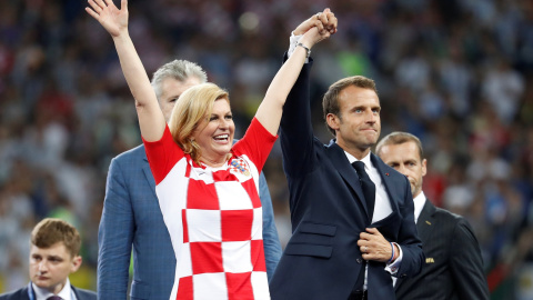 Emmanuel Macron levanta la mano de la presidenta de Croacia Kolinda Grabar-Kitarovic. REUTERS