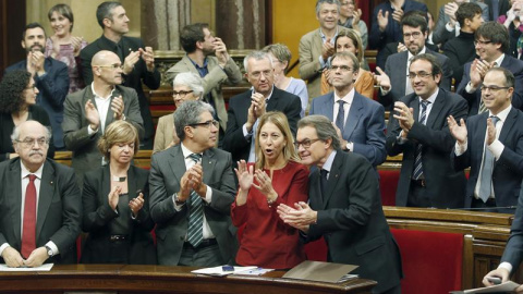 El presidente de la Generalitat en funciones, junto a miembros de su gobierno y diputados de Junts pel Si, aplaude tras aprobarse en el Parlament de Catalunya la resolución conjunta de Junts pel Sí y la CUP./ EFE