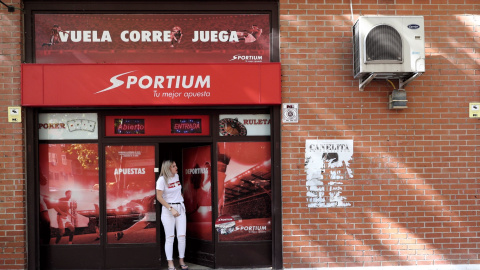 Local de apuestas de Sportium con una chica en la puerta de entrada. Arriba hay un cartel en el que se lee `Vuela, corre, juega´, en Madrid, a 3 de octubre de 2019.