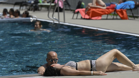 Imagen de archivo de una mujer tumbada en el bordillo de la piscina durante sus vacaciones. - EUROPA PRESS