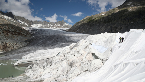 21/08/2019- Varias personas cubren la Cueva de Hielo con material para evitar que el hielo se derrita, en el Glaciar Rhone (Suiza). REUTERS / Denis Balibouse