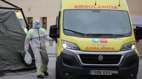 Un sanitario completamente protegido accede a una ambulancia junto al área donde soldados del Mando de Ingenieros de Salamanca del Ejército de Tierra