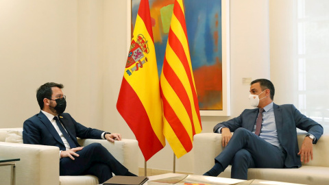 El presidente del Gobierno, Pedro Sánchez (d), conversa con el presidente de la Generalitat, Pere Aragonès, durante su encuentro este martes en el Palacio de la Moncloa.