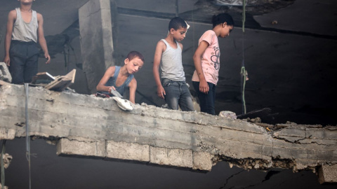 Varios niños palestinos miran los daños tras un ataque israelí en el campo de refugiados de Nuseirat, a 13 de julio de 2024.