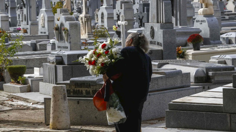 Una mujer con flores visita el madrileño cementerio de La Almudena, el Día de Difuntos. EFE/Paco Campos