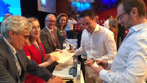 Fotos del momento del sorteo para decidir que candidato habla primero ante los compromisarios del PP./PÚBLICO