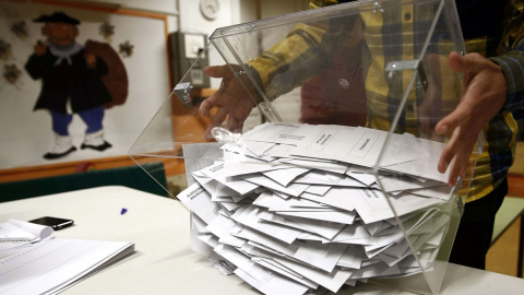 El presidente de una mesa electoral deposita los votos de la urna sobre una mesa para proceder a su recuento./EFE/Jesús Diges