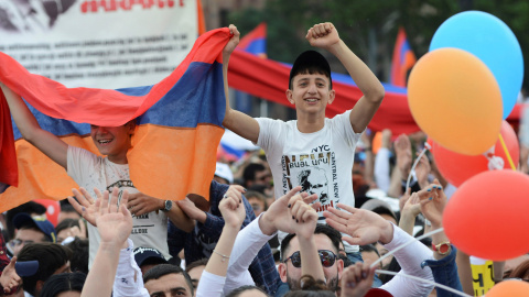 Dos jóvenes armenios portando una bandera durante una concentración en Yereván, Armenia. / Reuters