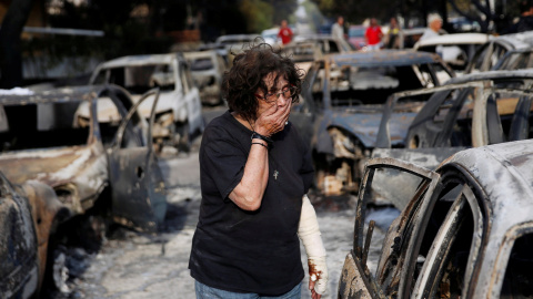 Una mujer busca a su perro después del incendio en el pueblo de Mati. REUTERS/Costas Baltas