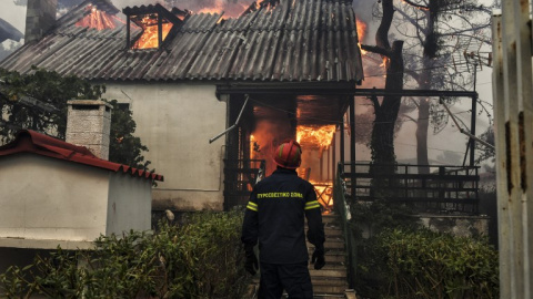 Un bombero frente a una casa en llamas en el incendio de Kineta, cerca de Atenas - AFP