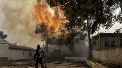 Un bombero trata de apagar las llamas del incendio de Kineta, cerca de Atenas - AFP