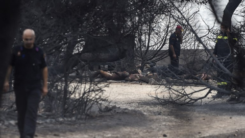 Rescatadores junto a las víctimas del incendio de Mati, cerca de Atenas - AFP