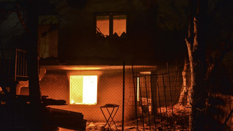 Una casa arde durante el incendio de Mati - AFP