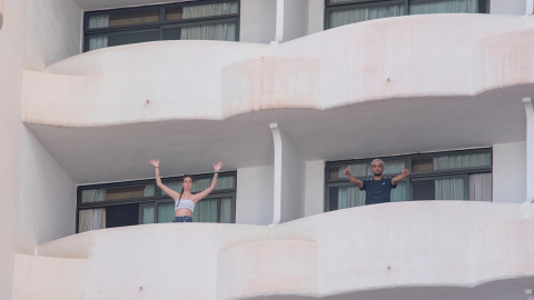 Dos jóvenes que permanecen en aislamiento en el hotel Palma Bellver de Palma saludan desde los balcones de sus habitaciones, este martes 29 de junio en Palma de Mallorca.