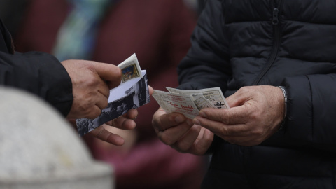 Una persona con varios décimos de lotería de Navidad cuando quedan menos de tres semanas para el Sorteo Extraordinario de la Lotería de Navidad, a 7 de diciembre de 2021, en Madrid (España).