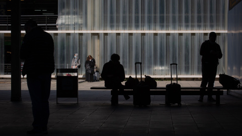 Una persona sentada en un banco junto a su equipaje en el Aeropuerto de Barcelona-El Prat, a 19 de noviembre de 2021.