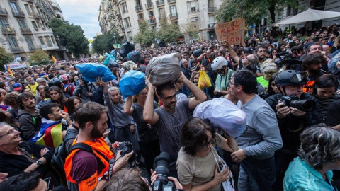 Milers de persones porten bosses de brossa per ser llançades a la vora de la Delegació del govern espanyol a Barcelona. EFE / Enric Fontcuberta