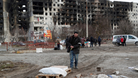 Un hombre recoge sus pertenencias cerca de un bloque de pisos destruido destruido tras un bombardeo en Mariupol.