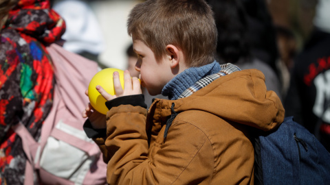 Un niño que ha huido de Ucrania después de la guerra espera afuera de una oficina del centro de inmigración en Bruselas.