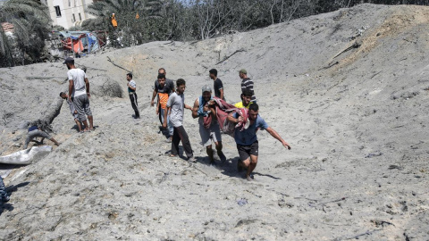 Varios palestinos trasladan un cuerpo sin vida tras un ataque aéreo israelí en la zona de Mawasi, al sur de la Franja de Gaza, el 13 de julio de 2024.