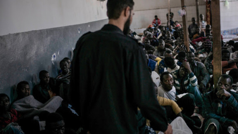 Un militar libio custodia a cientos de personas encerradas en una centro de detención de inmigrantes de Libia-. MSF