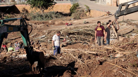 Varios vecinos realizan tareas de limpieza en la población de L'Espluga de Francolí (Tarragona) muy afectada por las riadas de esta semana,mientras los equipos de rescate ha intensificado este viernes la búsqueda de los 4 desaparecidos en las riadas. E