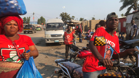 Varias personas vestidas con camisetas del partido gobernante, el Frelimo, en un mercado en Beira, Mozambique.- REUTERS / Emma Rumney