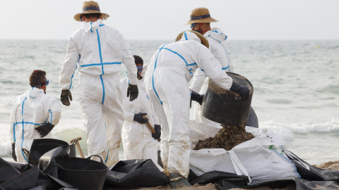 Varios operarios trabajan en la limpieza de la playa afectada por el vertido de hidrocarburos en València, a 17 de julio de 2024.