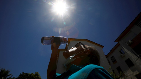 Un hombre bebe agua para aliviar las altas temperaturas registradas en Córdoba.