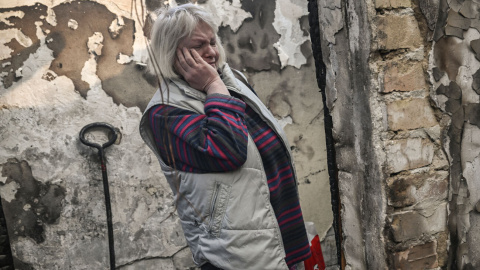 Una mujer observa el estado de su vivienda tras sufrir los efectos de un bombardeo en el barrio de Shevchenko, en Kiev, este miércoles. Aris Messinis/AFP