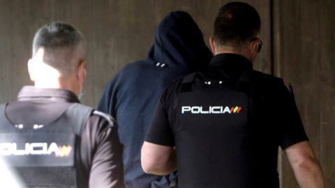 Agentes de la Policía Nacional conducen a uno de los cuatro detenidos por el homicidio de Samuel este viernes al interior de los juzgados de la Coruña.